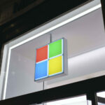 Imagem com a fachada de uma loja da Microsoft, tirada à noite.